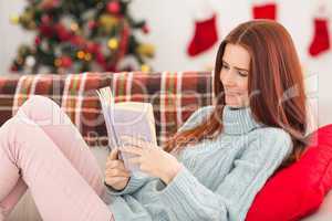 Festive redhead reading on the couch