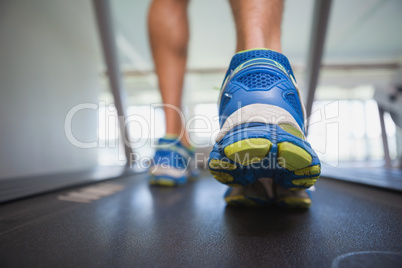 Low section of a man running on treadmill