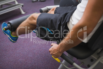 Side view of man doing leg workout at gym