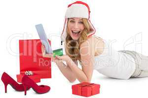 Woman holding a credit card surrounded with gifts