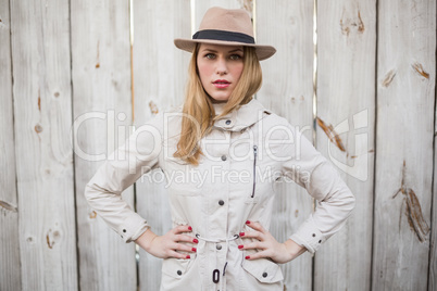 Blonde woman with hat posing with hand on hips