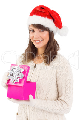 Brunette opening christmas gift while looking at camera