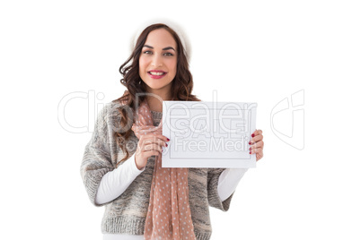 Brunette in winter clothes holding sale sign