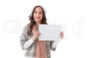 Brunette in winter clothes holding sale sign