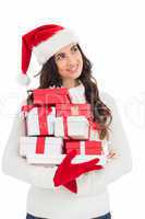 Joyful brunette in santa hat and red gloves holding pile of gift