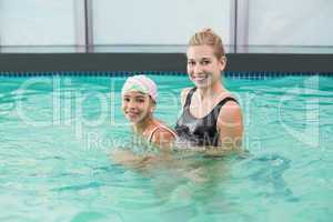 Cute little girl learning to swim with coach