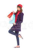 Happy brunette in winter clothes holding shopping bags