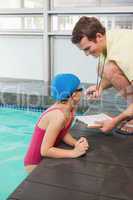 Swimming coach showing time to little girl