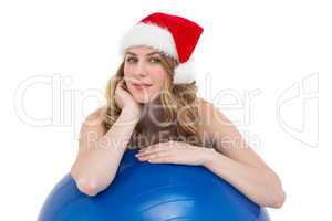 Festive fit blonde leaning on exercise ball