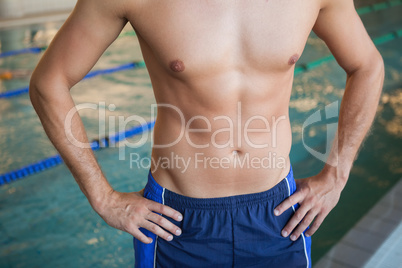 Mid section of a shirtless fit swimmer by pool