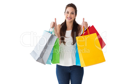 Happy brunette holding bags with thumbs up