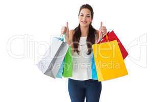 Happy brunette holding bags with thumbs up