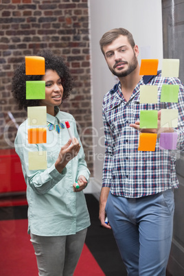 Business team looking at sticky notes on window