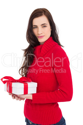 Smiling brunette in red jumper hat holding a gift