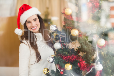 Smiling brunette decorating a christmas tree