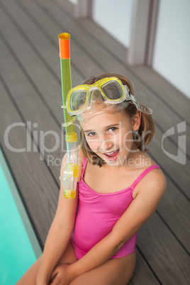 Cute little girl sitting poolside