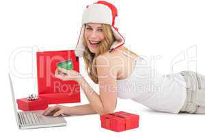 Happy woman shopping online lying on the floor