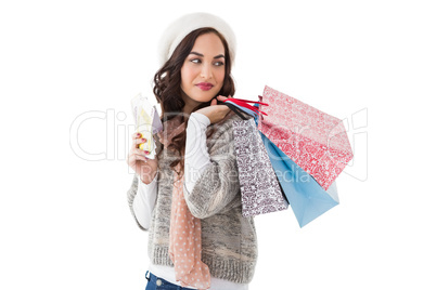 Brunette holding cash and shopping bags