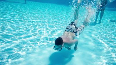 Teenager floats under water in pool