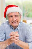 Portrait of mature man in santa hat with hands together