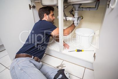 Plumber fixing under the sink