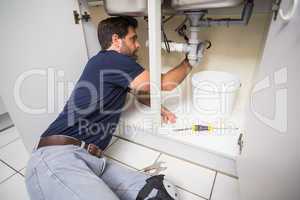 Plumber fixing under the sink