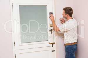 Man hand sanding the door before refinishing