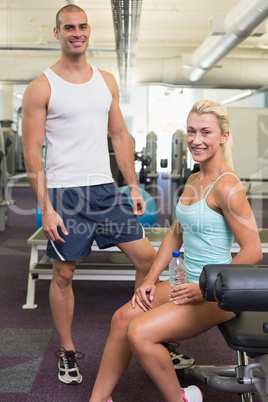 Fit smiling young couple in gym