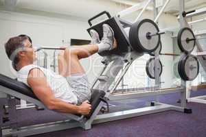 Fit man using weights machine for legs