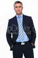 Smiling businessman in suit with hands in pocket posing