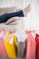 Woman lying on couch with shopping bags