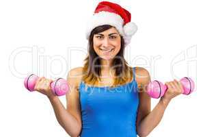 Festive fit brunette holding dumbbells