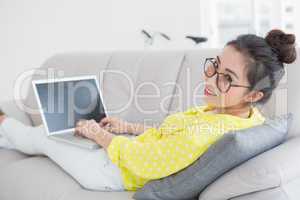 Young creative woman using laptop on couch