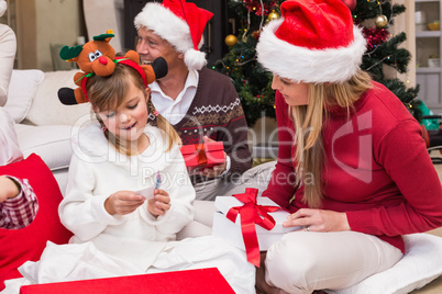 Daughter opening christmas gift with mother