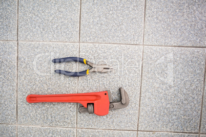 Wrench and pliers on bathroom floor