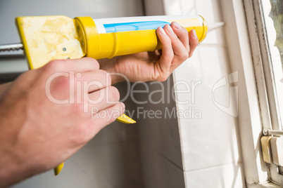 Hands putting filling between window and wall