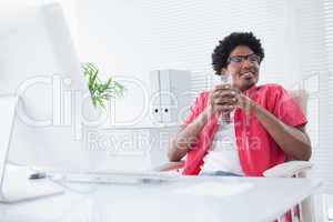 Relaxed businessman holding glass of milkshake