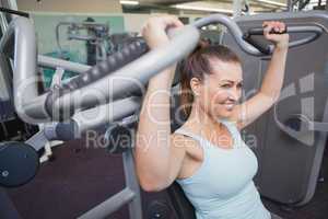 Fit brunette using weights machine for arms