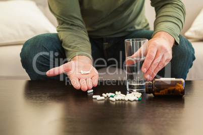 Casual man showing pills on open hand