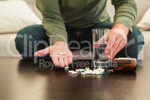 Casual man showing pills on open hand