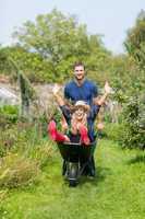 Man pushing his girlfriend in a wheelbarrow