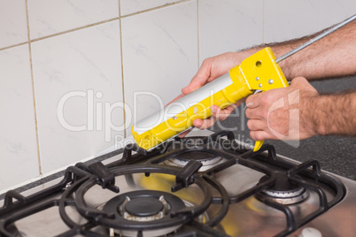 Plumber putting filling in between tiles