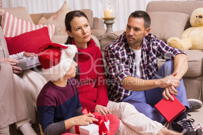 Thinking family sitting and holding gifts