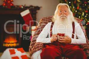 Smiling santa holding  cup of coffee