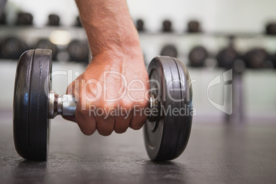 Fit man lifting heavy black dumbbell