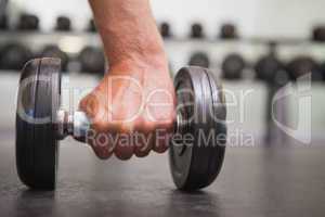 Fit man lifting heavy black dumbbell