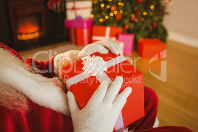 Santa claus holding a red gift