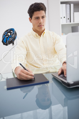 Concentrated designer using laptop and degitizer