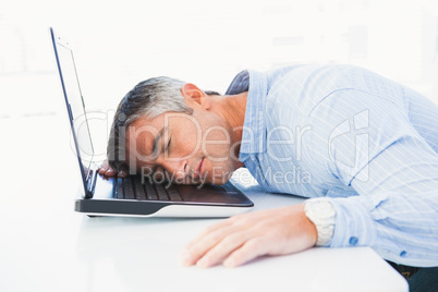 Man with grey hair sleeping on his laptop