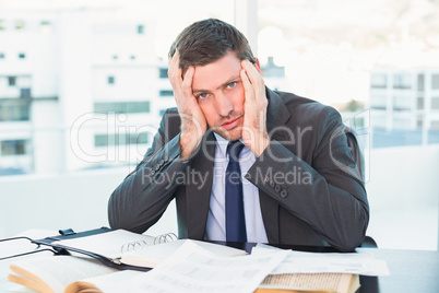 Stressed businessman with head in hands